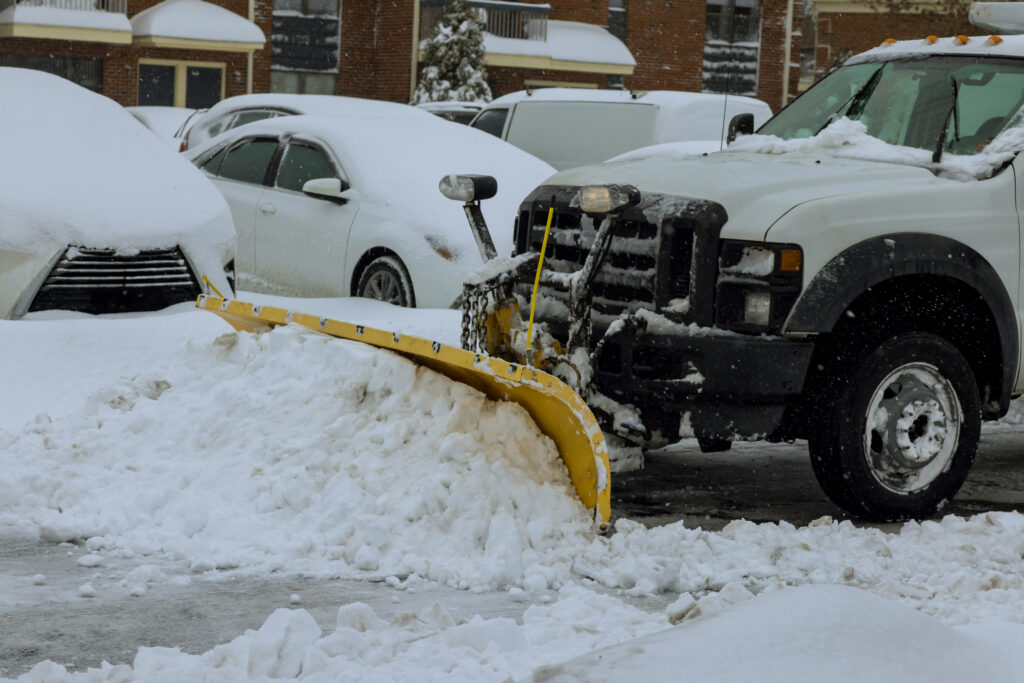 Snow plow clearing snow in a condo parking lot