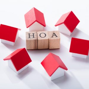 Homeowner Association Wooden Blocks Surrounded With Miniature House Models Over The White Background